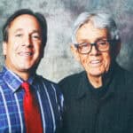 Sean O'Leary with an elderly man, both smiling, in a professional studio setting.