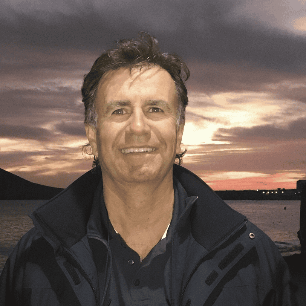 Portrait of Sean O'Leary with a sunset background by the water.