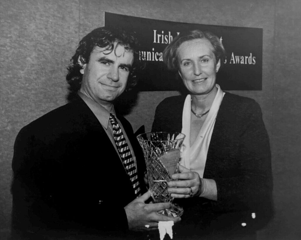 Award recipient with a woman holding a trophy.